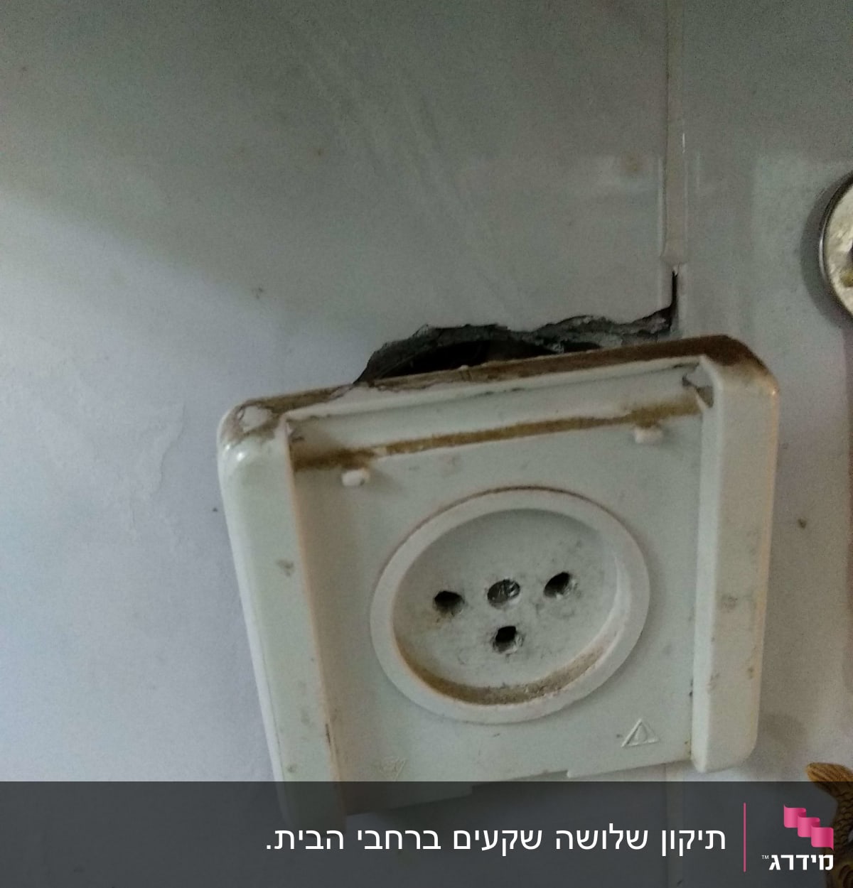 שקע חשמלי ישן עם סדקים בקיר